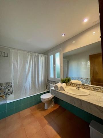 a bathroom with a toilet and a sink and a tub at Villas Serena in Cala Blanca