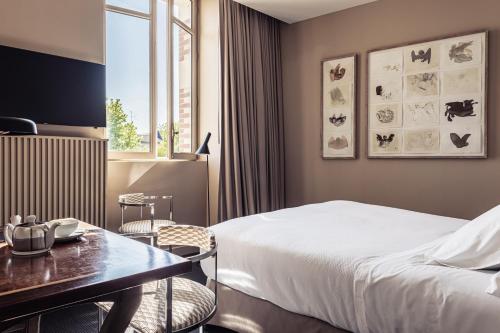 a hotel room with a bed and a table at Villa Mirasol in Mont-de-Marsan