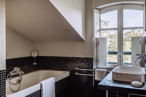a bathroom with a tub and a sink and a window at Villa Mirasol in Mont-de-Marsan
