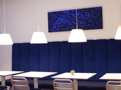 a row of tables and chairs in a room with lights at Hotel Colombia in Trieste
