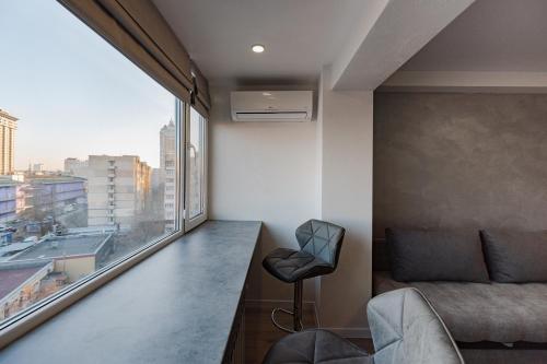 a living room with a couch and a large window at CityApartments Kyiv Obolon in Kyiv