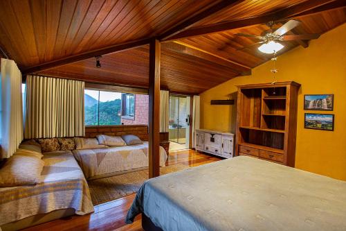 a bedroom with two beds and a large window at Sitio Jatoba/Lapinha da Serra in Santana do Riacho