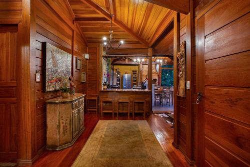a hallway with wood paneling and a kitchen with a bar at Sitio Jatoba/Lapinha da Serra in Santana do Riacho