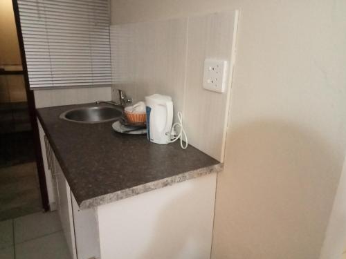 a small kitchen with a sink and a counter top at Emampingeni lodge in Bizana