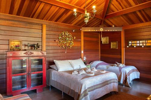two beds in a room with wooden walls at Sitio Jatoba/Lapinha da Serra in Santana do Riacho