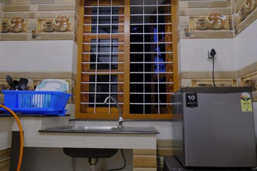 a kitchen with a sink and a window at BLUE SOPHY Residency in Varkala
