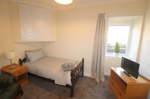 ein kleines Schlafzimmer mit einem Bett und einem Fenster in der Unterkunft Winmar in Inverness