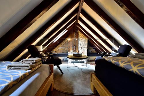 a attic room with two beds and a table and a window at Holiday Home Marko in Trilj