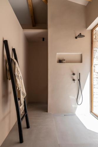 a black chair in a room with a shower at Pera Perou unspoiled luxury villas in Ayia Evfimia