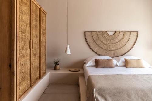 a bedroom with a bed and a wooden cabinet at Pera Perou unspoiled luxury villas in Ayia Evfimia