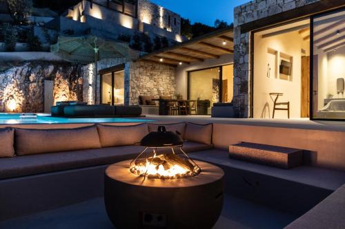 a patio with a couch and a swimming pool at night at Pera Perou unspoiled luxury villas in Ayia Evfimia