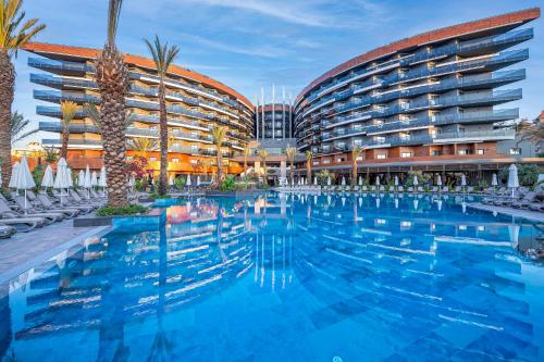 a hotel with a swimming pool in front of a building at Kirman Calyptus Resort & SPA in Side