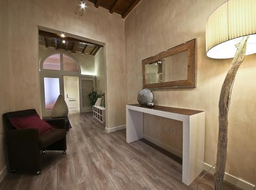 un soggiorno con una sedia e uno specchio di Apartments Florence - Giglio santa trinita a Firenze