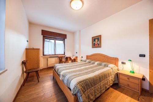a bedroom with a bed and a table and a window at La pratolina piano terra in Castello di Fiemme