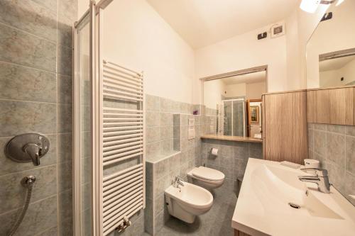 y baño con aseo, lavabo y ducha. en La pratolina piano terra, en Castello di Fiemme
