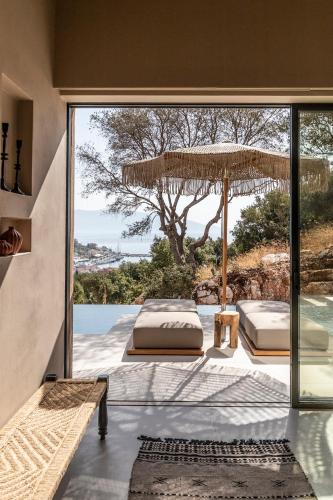 a bedroom with two beds and a large glass window at Pera Perou unspoiled luxury villas in Ayia Evfimia