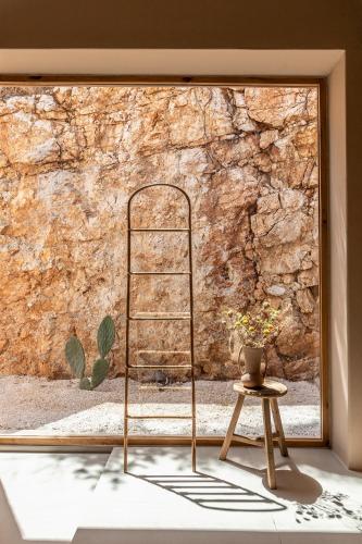 a metal shelf in front of a stone wall at Pera Perou unspoiled luxury villas in Ayia Evfimia