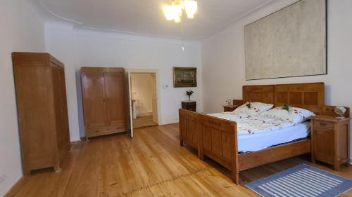 1 dormitorio con 1 cama grande y suelo de madera en Pfarrschlössl Sallapulka, en Purgstall
