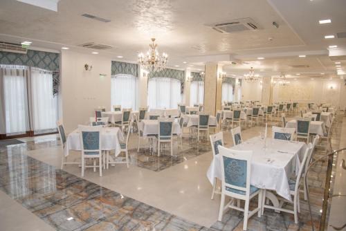 a banquet hall with white tables and chairs at VILA SILFAR in Măcin