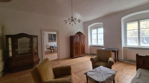 a living room with chairs and a table and a chandelier at Pfarrschlössl Sallapulka in Purgstall