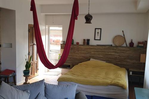 1 dormitorio con 1 cama con cabecero de madera en דירת סטודיו מעוצבת עם מרפסת גג גדולה, en Rechovot