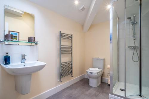 a bathroom with a sink and a toilet and a shower at The Warren - Kendal Town Centre, with Parking in Kendal