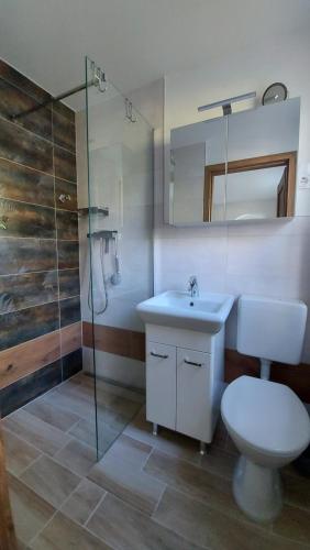 e bagno con servizi igienici, lavandino e doccia. di Ferienwohnung Hase und Igel a Sundhagen-Niederhof