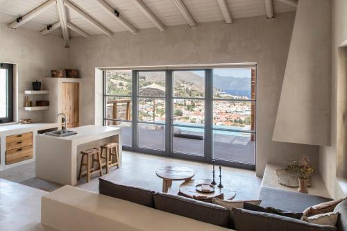 a kitchen and living room with a large window at Pera Perou unspoiled luxury villas in Ayia Evfimia