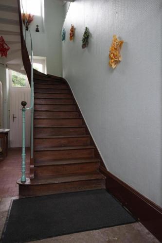 a staircase in a house with wooden steps and a wall at La Chaussée de l'Etang in Marcenay