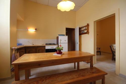 a kitchen with a wooden table and a refrigerator at La Chaussée de l'Etang in Marcenay