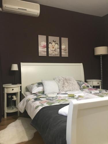 a bedroom with a white bed and two tables at REoN Apartment, Osijek - self CHECK IN in Osijek