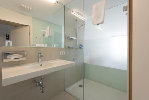 W łazience znajduje się umywalka i przeszklony prysznic. w obiekcie Hotel Seegasthof Oberndorfer w Attersee am Attersee