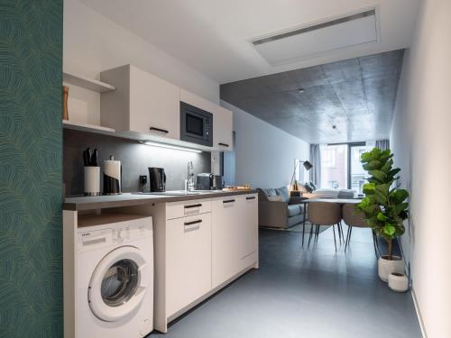 a kitchen with a washer and dryer in a room at Limehome Erfurt Maximilian Welsch Str in Erfurt