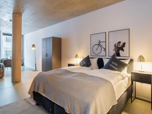 a bedroom with a large bed with two pictures on the wall at Limehome Erfurt Maximilian Welsch Str in Erfurt