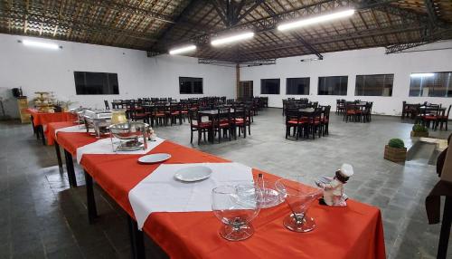 un comedor con mesas y sillas rojas y mesa en Recanto Varandas Guararema, en Guararema