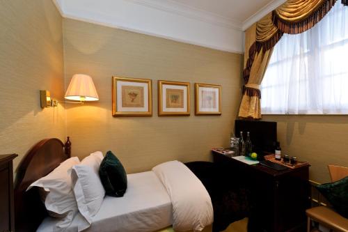a hotel room with a bed and a desk at The Colonnade in London