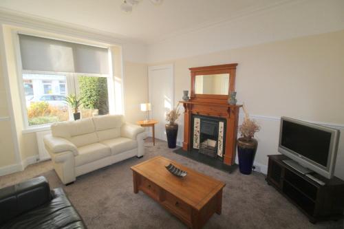 a living room with a white couch and a television at Winmar in Inverness