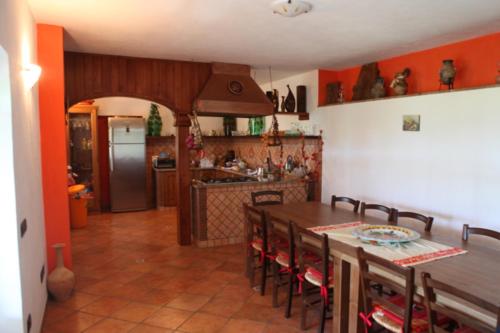 a kitchen with a wooden table and a kitchen with a refrigerator at Colle Uliveto in Vico Equense
