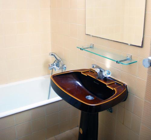bagno con lavandino in legno e vasca. di BEACH FLAT COSTA DA CAPARICA a Costa da Caparica