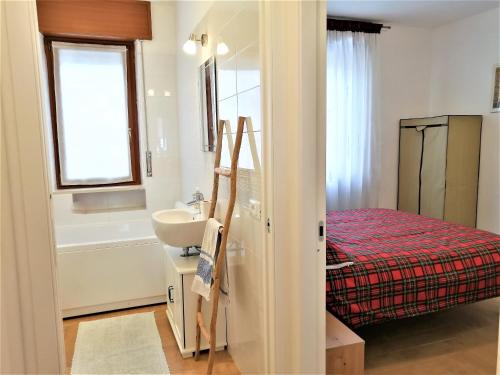een badkamer met een wastafel, een bed en een bad bij Appartamento con 3 camere in centro Aosta CIR-AOSTA-0325 in Aosta