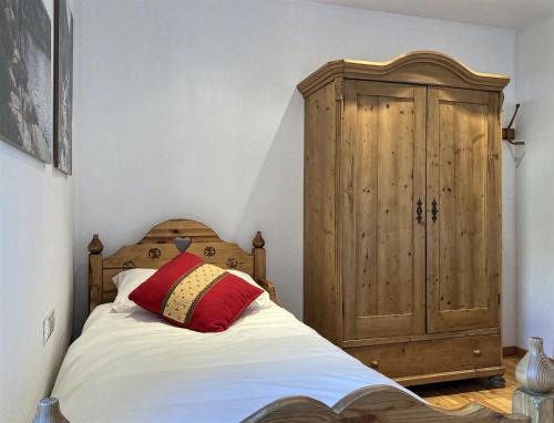1 dormitorio con 1 cama y armario de madera en Casa Gialla, en Varena