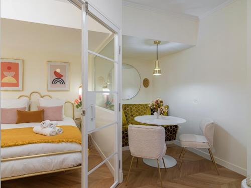 1 dormitorio con 1 cama, lavamanos y mesa en The Margarette Suite, en París