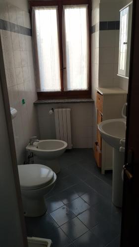 een badkamer met 2 toiletten, 2 wastafels en 2 ramen bij Appartamenti Sella&Mosso! Vespolina in Mosso Santa Maria