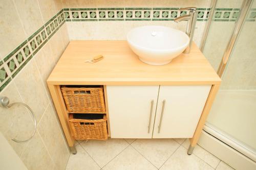 a bathroom vanity with a sink and a shower at COSY HOUSE Créteil 3 pièces in Créteil