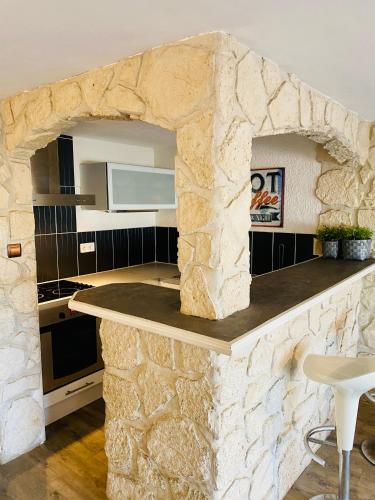 - une cuisine avec un mur en pierre et un comptoir dans l'établissement 