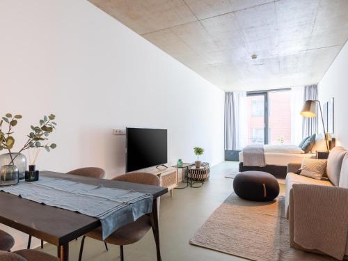 a living room with a table and a couch and a bed at Limehome Erfurt Maximilian Welsch Str in Erfurt