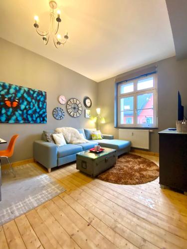 a living room with a blue couch and a table at Die kleine Post in Schleiden