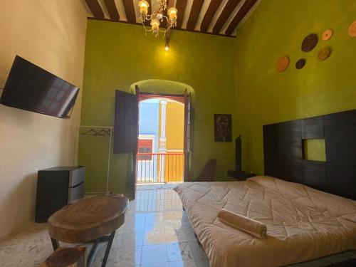 een slaapkamer met een bed, een tafel en een raam bij Hotel Edzna in Campeche