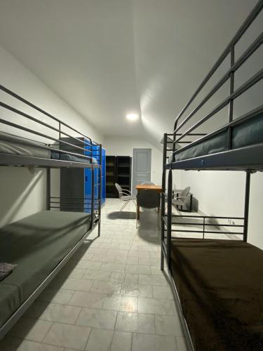 Zimmer mit 2 Etagenbetten und einem Schreibtisch in der Unterkunft Hôtel Pincevent in La Queue-en-Brie