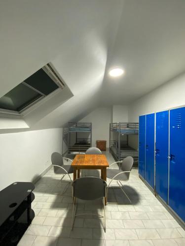 a room with a table and chairs and blue lockers at Hôtel Pincevent in La Queue-en-Brie